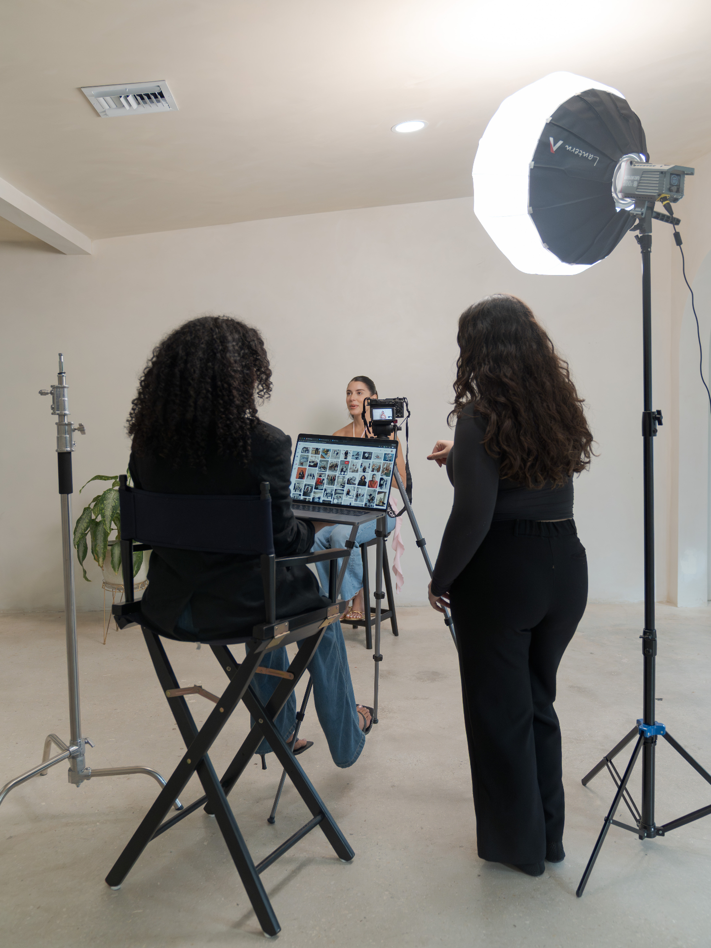 Behind the scenes in a studio, reviewing content on a laptop with a light and camera set up